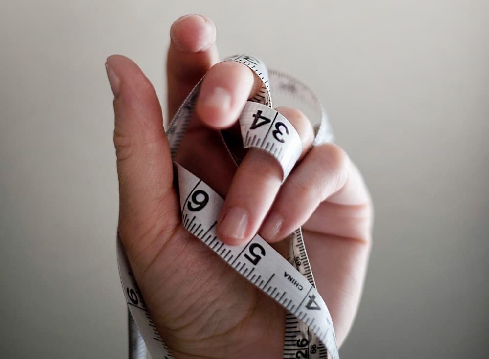 Person comparing ring sizes, illustrating the frustration of guessing ring size when shopping online